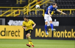Schalke's Belgian forward Benito Raman (R) vies with Dortmund's German defender Mats Hummels during the German first division Bundesliga football match BVB Borussia Dortmund v Schalke 04 on May 16, 2020 in Dortmund, western Germany as the season resumed following a two-month absence due to the novel coronavirus COVID-19 pandemic. PHOTO: MARTIN MEISSNER / POOL / AFP