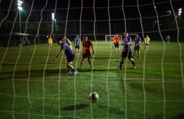 (FILES) This file photo taken on May 19, 2020 shows people playing football in a field in Wuhan, in Chinaís central Hubei province. - For nearly three months football enthusiasts in Wuhan were left kicking their heels indoors as the coronavirus raged in the Chinese city at the epicentre of the outbreak. But since the harsh lockdown on the city of 11 million people ended in early April amateur footballers have been gleefully ripping off their face masks and lacing up their boots again. (Photo by Hector RETAMAL / AFP)