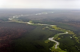 A aerial view of the Pibor river flowing across the landscape between Boma and Badingilo national parks on February 4, 2020. - South Sudan holds enormous ecotourism potential, boasting Africa's largest savanna and wetland, the second-largest mammal migration on earth, and the lions, elephants and myriad other endangered and iconic species that have long lured visitors to the continent. (Photo by TONY KARUMBA / AFP)