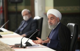 A handout picture provided by the Iranian presidency on May 30, 2020, shows President Hassan Rouhani (R) and the mask-clad Minister of Health and Medical Education Saeed Namaki amid the COVID-19 pandemic, during a cabinet session in the capital Tehran. - Rouhani announced that collective prayers will resume in mosques, even as confirmed coronavirus infections rise again after a decline. PHOTO: IRANIAN PRESIDENCY / AFP