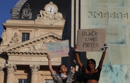 Protesters hold placards reading "Love of loved ones is not hatred of others" (L) and "Balck Lives Mattar" during a protest at Place Joffre in front of the Invalides in Paris on June 6, 2020, as part of "Black Lives Matter" worldwide protests against racism and police brutality in the wake of the death of George Floyd, an unarmed black man killed while apprehended by police in Minneapolis, US. - Police banned the rally as well as a similar second one on the Champ de Mars park facing the Eiffel Tower today, saying the events were organised via social networks without official notice or consultation. But on June 2, another banned rally in Paris drew more than 20000 people in support of the family of Adama Traore, a young black man who died in police custody in 2016. (Photo by GEOFFROY VAN DER HASSELT / AFP)