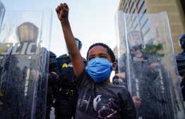 A young boy raises his fist for a photo by a family friend during a demonstration in Atlanta.
PHOTO: ELIJAH NOUVELAGE / GETTY IMAGES