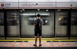 In this picture taken on October 23, 2019, then-17-year old high-school student Joseph poses on a platform at the Prince Edward underground train station in Hong Kong, where on the evening of August 31 he and others were allegedly clubbed repeatedly with batons inside a waiting train after a team of riot police stormed into station, causing him to need 14-stitches to close a head wound, a moment that has fuelled his desire to become a lawyer as he tries to sue the force. - Despite spending 48 hours handcuffed to a hospital gurney under arrest as he was treated, Joseph was not charged with any crime and no police officer has faced any sanction for their tactics inside Prince Edward station. (Photo by Anthony WALLACE / AFP) / 