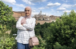 A handout picture provided by by Palestinian Aseel Bader taken on May 28, 2020 shows her posing for a picture in Italy's northern city of Siena, with the Siena Cathedral (Duomo di Siena) seen in the background. - Thousands of Palestinians left stranded around the world by coronavirus are still seeking a way home, months after countries closed their borders and grounded flights over the pandemic. Aseel Bader touched down in Tuscany in January, after winning a scholarship for a master's programme at the University of Florence. Just weeks later Italy imposed a nationwide lockdown as the coronavirus spread rapidly, prompting Bader to look for a way back to Hebron in the occupied West Bank. (Photo by - / FAMILY HANDOUT / AFP) / 