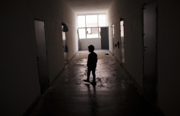 An image of a lone child in a desolate building.