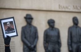 A protester holds up a photo of George Floyd in front of a memorial dedicated to lynching victims in Duluth, Minn., on May 30, 2020. PHOTO: AFP