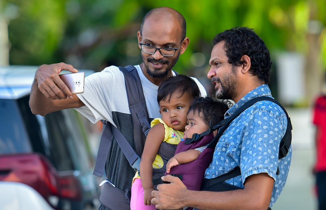 މާލެ: ޖޫން 15، 2020- ކޮވިޑް-19 އިން ރައްކާތެރިވުމަށް މާލެ ސަރަހައްދުގައި އިއުލާން ކޮށްފައިވާ ލޮކްޑައުން އަށް ދިން ލުޔާ އެކު، ޖުމްހޫރީ މައިދާން ސަރަަހައްދަށް ކުޑަކުދިން ގޮވައިގެން ދިޔަ ބަޔަކު ސެލްފީއެއް ނަގަނީ.---ފޮޓޯ: އަހުމަދު އަވްޝަން/މިހާރު