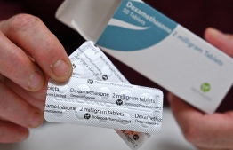 A pharmacist holds a box of dexamethasone tablets at a chemists shop in London on June 16, 2020. - The steroid dexamethasone was shown Tuesday to be the first drug to significantly reduce the risk of death among severe COVID-19 cases, in trial results hailed as a "major breakthrough" in the fight against the disease. (Photo by JUSTIN TALLIS / AFP)