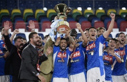Napoli's Italian forward Lorenzo Insigne (C holding trophy), Napoli's Italian head coach Gennaro Gattuso (L) and players celebrate after winning the TIM Italian Cup (Coppa Italia) final football match Napoli vs Juventus on June 17, 2020 at the Olympic stadium in Rome, played behind closed doors as the country gradually eases the lockdown aimed at curbing the spread of the COVID-19 infection, caused by the novel coronavirus. (Photo by Filippo MONTEFORTE / AFP)