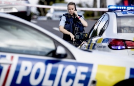 A police officer cordons off an area after a shooting incident in a residential neighbourhood in Auckland on June 19, 2020. - An unarmed New Zealand police officer was shot dead on an Auckland street on June 19 in a rare fatal attack that Prime Minister Jacinda Ardern described as "devastating". (Photo by GREG BOWKER / AFP)