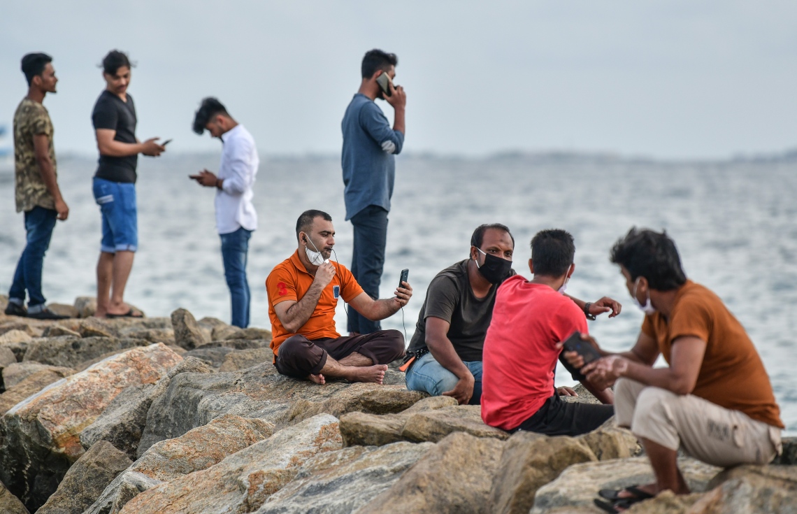 މާލެ: ޖޫން 21، 2020: މާލެ ސަރަހައްދަށް އިއުލާން ކޮށްފައިވާ ލޮކްޑައުން އަށް ލުޔެއް ދިނުމާއެކު، އިންޑަސްޓްރިއަލް ޒޯން ސަރަހައްދުގައި ގިނަ ބަޔަކު އެއްތަނެއްގައި އެއްވެސް ގައިދުރު ކުރުމެއް ނެތި މަޑުކޮށްލައިގެން.-- ފޮޓޯ: ނިޝާން އަލީ /މިހާރު