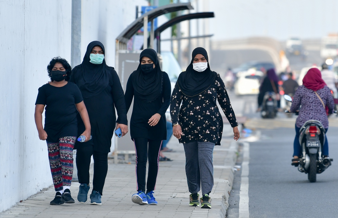 މާލެ: ޖޫން 21، 2020: މާލެ ސަރަހައްދަށް އިއުލާން ކޮށްފައިވާ ލޮކްޑައުން އަށް ލުޔެއް ދިނުމާއެކު، އަންހެނުންތަކެއް މާސްކު އަޅައިގެން ހުރި ނަމަވެސް އެއްވެސް ގައިދުރު ކުރުމެއް ނެތި މަގުމަތީ ހިނގާފައި ދަނީ.-- ފޮޓޯ: ނިޝާން އަލީ /މިހާރު