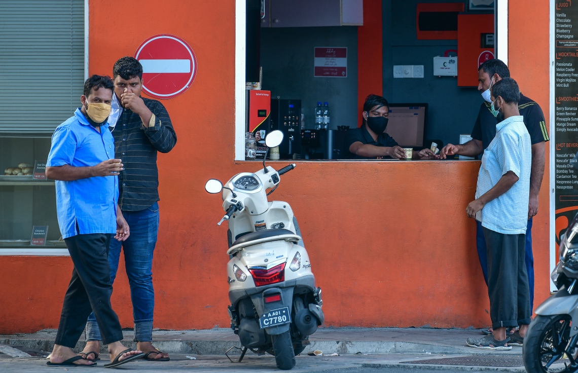 މާލެ: ޖޫން 21، 2020: މާލެ ސަރަހައްދަށް އިއުލާން ކޮށްފައިވާ ލޮކްޑައުން އަށް ލުޔެއް ދިނުމާއެކު، ކޮފީ ޝޮޕެއް ކައިރީގައި ބަޔަކު އެއްވެސް ގައިދުރު ކުރުމެއް ނެތި ކޮފީ ބޯން މަޑުކޮށްލައިގެން.-- ފޮޓޯ: ނިޝާން އަލީ /މިހާރު