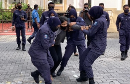 Maldives Police Service (MPS) officers, seemingly using a large amount of force, to remove an activist peacefully protesting in front of the Parliament. PHOTO: NAVAANAVAI