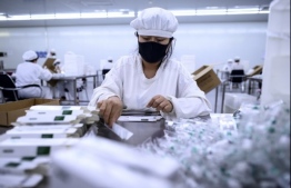 This photo taken on June 9, 2020 shows a worker packaging rabies vaccines at a lab at the Yisheng Biopharma company, where researchers are trying to develop a vaccine for the COVID-19 coronavirus, in Shenyang, in China's northeast Liaoning province. - Inside Yisheng Biopharma, one of the Chinese labs racing to create a coronavirus vaccine, researchers work weekends, lab monkeys are in short supply and plans are being made for human trials abroad. (Photo by NOEL CELIS / AFP) / 