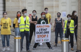 Climate and Anti-capitalist activists demonstrate on June 17, 2020 in front of the French Economy and Finance minister against US e-commerce company Amazon they accuse of tax fraud, price and social dumping. (Photo by Ludovic MARIN / AFP)