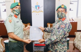 Chief of Defence Force Major General Abdulla Shamaal, presents Colonel Ibrahim Hilmy with his letter of appointment as Maldives National Defence Force (MNDF)'s Central Area Commander during a special ceremony held at MNDF Headquarters 'Bandaara Koshi'. PHOTO: MNDF