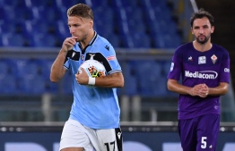 Lazio's Italian forward Ciro Immobile (L) reacts after scoring a penalty during the Italian Serie A football match Lazio vs Fiorentina played on June 27, 2020 behind closed doors at the Olympic stadium in Rome, as the country eases its lockdown aimed at curbing the spread of the COVID-19 infection, caused by the novel coronavirus. (Photo by Alberto PIZZOLI / AFP)