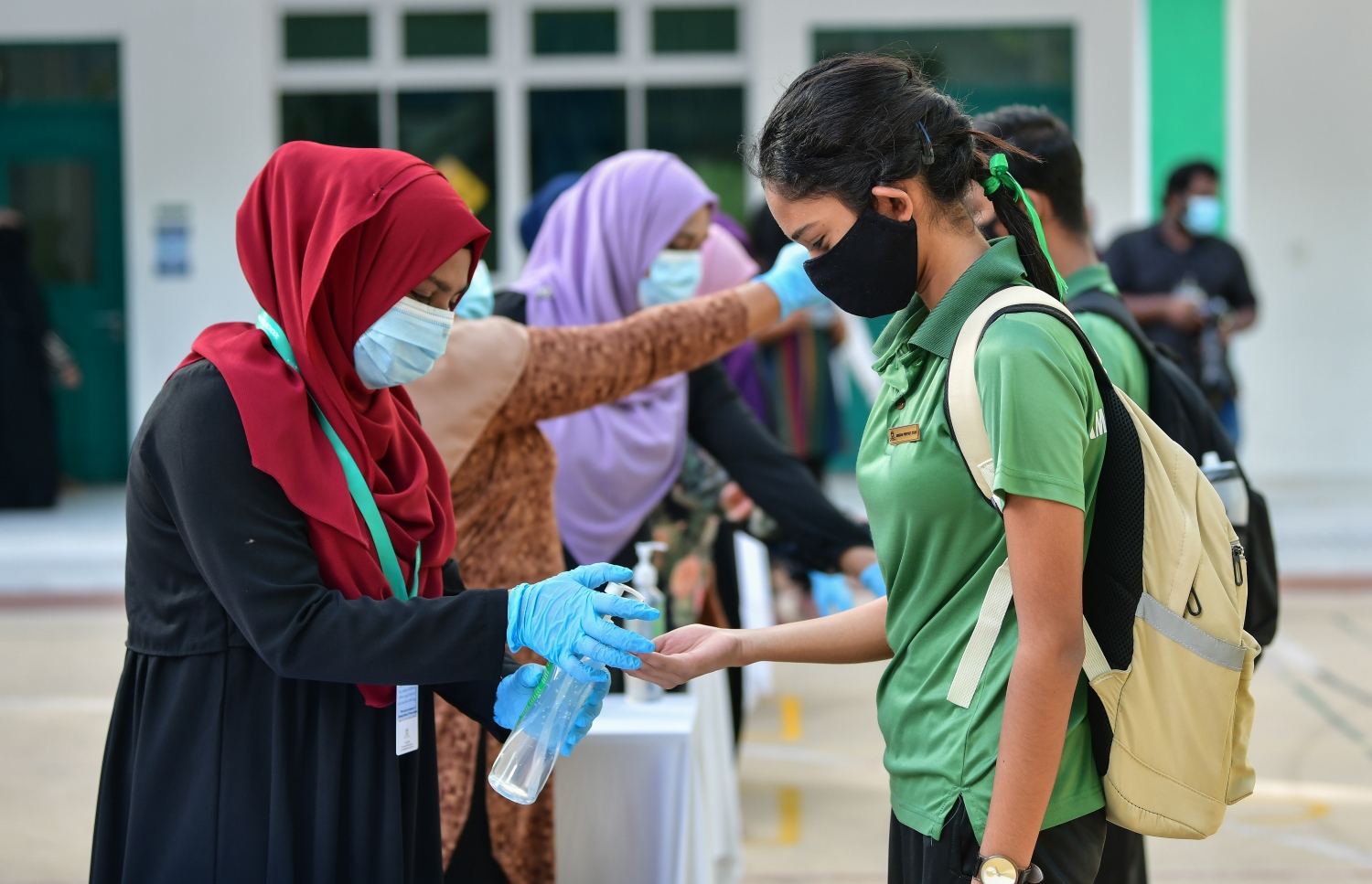 އަމީނިއްޔާ ސްކޫލުގެ ޓިޗަރުންތަކެއް ދަރިވަރުން އަތަށް ސެނެޓައިޒާ އަޅައިދެނީ.-- ފޮޓޯ: ނިޝާން އަލީ /މިހާރު