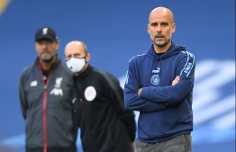 Manchester City's Spanish manager Pep Guardiola (R) watches from the touchline during the English Premier League football match between Manchester City and Liverpool at the Etihad Stadium in Manchester, north west England, on July 2, 2020. PHOTO: LAURENCE GRIFFITHS / POOL / AFP