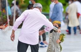 An elderly man and a child bump elbows to avoid shaking hands following the first congregational Friday prayer held within the capital Male' in four months. PHOTO: AHMED AWSHAN ILYAS / MIHAARU