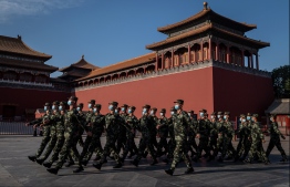 (FILES) In this file photo paramilitary police officers wearing face masks march in front of the entrance of the Forbidden City in Beijing on May 19, 2020. - The United States on July 9, 2020 again invited China to talks on arms control, saying it saw an opening with Beijing on three-way negotiations with Russia despite intense disagreements. "The United States welcomes China's commitment to engage in arms control negotiations. As such, prudent next steps will need to include face-to-face meetings between the United States and China," State Department spokeswoman Morgan Ortagus said. PHOTO: NICOLAS ASFOURI / AFP