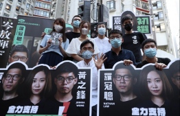 (Back row L-R) Agnes Chow, Anthony Wong, Tiffany Yuen, Denise Ho, Lester Shum (front row L-R) Eddie Chu, Joshua Wong, and Gregory Wong pose while compaigning during a primary election in Hong Kong on July 11, 2020. - Pro-democracy parties in Hong Kong held primary polls on July 11 to choose candidates for upcoming legislative elections despite warnings from government officials that it may be in breach of a new security law imposed by China. PHOTO: MAY JAMES / AFP