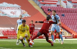 Liverpool's Senegalese striker Sadio Mane (2R) tries to get the ball past Burnley's English goalkeeper Nick Pope during the English Premier League football match between Liverpool and Burnley at Anfield in Liverpool, north west England on July 11, 2020. (Photo by PHIL NOBLE / POOL / AFP) / RESTRICTED TO EDITORIAL USE. No use with unauthorized audio, video, data, fixture lists, club/league logos or 'live' services. Online in-match use limited to 120 images. An additional 40 images may be used in extra time. No video emulation. Social media in-match use limited to 120 images. An additional 40 images may be used in extra time. No use in betting publications, games or single club/league/player publications. / 