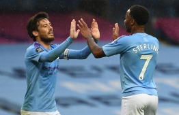 Manchester City's English midfielder Raheem Sterling (R) high fives Manchester City's Spanish midfielder David Silva (L) after Sterling scored their fifth goal during the English Premier League football match between Manchester City and Newcastle United at the Etihad Stadium in Manchester, north west England, on July 8, 2020. (Photo by Oli SCARFF / POOL / AFP) / RESTRICTED TO EDITORIAL USE. No use with unauthorized audio, video, data, fixture lists, club/league logos or 'live' services. Online in-match use limited to 120 images. An additional 40 images may be used in extra time. No video emulation. Social media in-match use limited to 120 images. An additional 40 images may be used in extra time. No use in betting publications, games or single club/league/player publications. / 