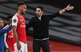 Arsenal's Spanish head coach Mikel Arteta (R) talks with Arsenal's Gabonese striker Pierre-Emerick Aubameyang (L) before bringing him on as a substitute during the English Premier League football match between Arsenal and Liverpool at the Emirates Stadium in London on July 15, 2020. (Photo by Shaun Botterill / POOL / AFP) / RESTRICTED TO EDITORIAL USE. No use with unauthorized audio, video, data, fixture lists, club/league logos or 'live' services. Online in-match use limited to 120 images. An additional 40 images may be used in extra time. No video emulation. Social media in-match use limited to 120 images. An additional 40 images may be used in extra time. No use in betting publications, games or single club/league/player publications. / 