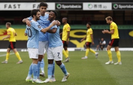 Manchester City's Portuguese midfielder Bernardo Silva (L), Manchester City's Spanish midfielder Rodri celebrate after Manchester City's English midfielder Raheem Sterling scored the opening goal during the English Premier League football match between Watford and Manchester City at Vicarage Road Stadium in Watford, north of London on July 21, 2020. (Photo by Adrian DENNIS / POOL / AFP)