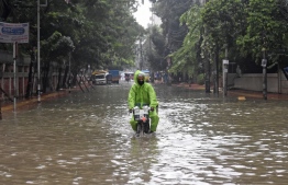 A man rides a bicycle through a water-logged street after a heavy downpour in Dhaka on July 21, 2020. - The death toll from heavy monsoon rains across South Asia has climbed to nearly 200, officials said on July 19, as Bangladesh and Nepal warned that rising waters would bring further flooding. (Photo by Munir Uz zaman / AFP)