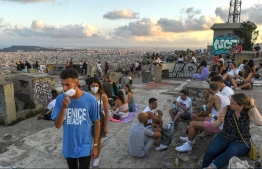 Young Spanish citizens on a hill overviewing Barcelona. PHOTO: DAVID RAMOS/ GETTY IMAGES