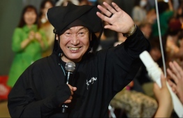 (FILES) This file photo taken on June 12, 2015 shows Japanese designer Kansai Yamamoto waving to the audience after an event in Tokyo. - Famed Japanese fashion designer Kansai Yamamoto has died of leukemia at the age of 76, his daughter announced on July 27, 2020. (Photo by Kazuhiro NOGI / AFP)