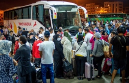 Moroccans gather in the "Ouled Ziane" bus station in Casablanca on July 26 ,2020 to leave the city before travel restrictions imposed by authorities to smother a new outbreak of the novel coronavirus. (Photo by Rizkou ABDELMJID / AFP)