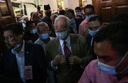 Malaysia's former prime minister Najib Razak (C) leaves the Duta Court complex after he was found guilty in his corruption trial in Kuala Lumpur on July 28, 2020. - Former Malaysian leader Najib Razak was sentenced on July 28 to 12 years in jail on corruption charges linked to the multi-billion-dollar 1MDB scandal that led to the downfall of his government two years ago. (Photo by Mohd RASFAN / AFP)