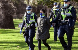 Police detain an anti-mask protester in Melbourne on July 31, 2020. - As greater Melbourne passed the halfway point of a lockdown initially intended to last six weeks, the state of Victoria - of which Melbourne is the capital - recorded over 600 new cases, leaving Premier Daniel Andrews to flag harsher restrictions in a bid to cut the infection rate. PHOTO: WILLIAM WEST / AFP