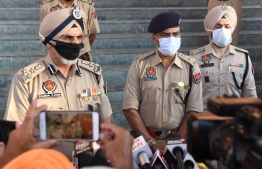 EDITORS NOTE:  / Punjab Police (DIG) Hardial Singh Mann (L) along with Police officers speaks to media persons at Tarn Taran, some 25 km from Amritsar on August 1, 2020. - At least 40 people have died in three Punjab's districts including Amritsar, Batala and Tarn Taran, after reportedly drinking spurious liquor over two days, local media reported on July 31. (Photo by NARINDER NANU / AFP)