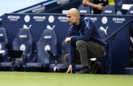 Manchester City's Spanish manager Pep Guardiola takes a knee during the English Premier League football match between Manchester City and Norwich City at the Etihad Stadium in Manchester, north west England, on July 26, 2020. PHOTO: PETER POWELL / POOL / AFP