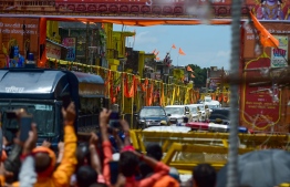 People wave India's Prime Minister's convoy arrives outside Hanuman Gadhi temple before the groundbreaking ceremony of the Ram Temple in Ayodhya on August 5, 2020. - India's Prime Minister Narendra Modi will lay the foundation stone for a grand Hindu temple in a highly anticipated ceremony on August 5 at a holy site that was bitterly contested by Muslims, officials said. The Supreme Court ruled in November 2019 that a temple could be built in Ayodhya, where Hindu zealots demolished a 460-year-old mosque in 1992. (Photo by Sanjay KANOJIA / AFP)