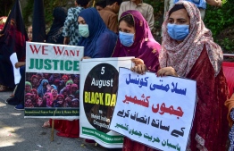 Kashmiris hold placards during a rally to show their solidarity with people of Indian-administered Kashmir, in Muzaffarabad, the capital of Pakistan-administered Kashmir on August 5, 2020, to mark the one-year anniversary of the restive Kashmir region being stripped of its autonomy. - Pakistani Prime Minister Imran Khan on August 5 branded India an "oppressor and aggressor" a year after New Delhi imposed direct rule on Indian-administered Kashmir. (Photo by Sajjad QAYYUM / AFP)