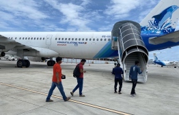 Expatriate workers board a Maldivian flight, for repatriation. PHOTO/MALDIVIAN