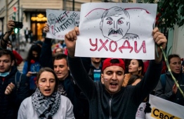 Demonstrators protest against the results of Belarusian presidential election outside the Belarusian embassy in Moscow on August 12, 2020. The placard features an image of Belarus' President Alexander Lukashenko and reads "Go away". (Photo by Dimitar DILKOFF / AFP)
