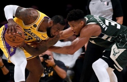 (FILES) In this file photo taken on March 6, 2020, LeBron James  (L) of the Los Angeles Lakers is guarded by Giannis Antetokounmpo of the Milwaukee Bucks during the third quarter at Staples Center in Los Angeles, California.    Harry How/Getty Images/AFP - Reigning NBA Most Valuable Player Giannis Antetokounmpo was named alongside Los Angeles Lakers star LeBron James and 2018 MVP James Harden as the finalist for this year's award on Saturday. (Photo by Harry How / GETTY IMAGES NORTH AMERICA / AFP)
