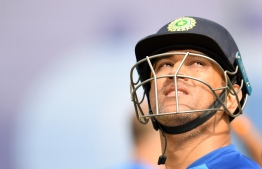 (FILES) In this file photo taken on July 8, 2019, India's Mahendra Singh Dhoni looks on after a session in the nets as he takes part in a training session at Old Trafford in Manchester, north-west England, ahead of their 2019 Cricket World Cup semi-final match against New Zealand. (Photo by Dibyangshu SARKAR / AFP) /