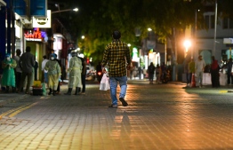 A pedestrian walks past a random sampling station in the capital city of Male'. PHOTO: AHMED AWSHAN ILYAS/ MIHAARU
