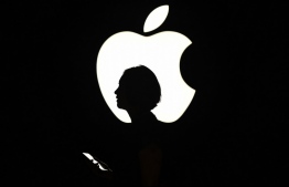 (FILES) In this file photo a reporter walks by an Apple logo during a media event in San Francisco, California on September 9, 2015. \ - Apple is locked in a legal battle with Epic games, the developer of renowned video game Fortnite. PHOTO: JOSH EDELSON / AFP