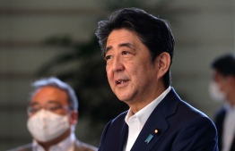 Japan's Prime Minister Shinzo Abe (C) speaks to the media upon his arrival at the prime minister's office in Tokyo on August 19, 2020. HOTO: KAZUHIRO NOGI / AFP