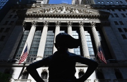(FILES) In this file photo the "Fearless Girl" statue stands in front of the New York Stock Exchange (NYSE) at Wall Street on June 29, 2020 in New York City. - US stocks opened the week like they closed last week: on a high note, amid news the US Food and Drug Administration (FDA) had authorized the use of a COVID-19 treatment. About 30 minutes into the August 24, 2020 trading session, the benchmark Dow Jones Industrial Average climbed 0.5 percent to 28,081.45.The broad-based S&P 500 jumped 0.7 percent to 3,419.92, and the tech-rich Nasdaq Composite Index increased 0.8 percent to 11,400.51, remaining buoyant after more than 30 record closes in 2020. (Photo by Angela Weiss / AFP)