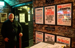 A doorman is seen at the entrance to the Cavern Club as it reopens to the public with live music to host their annual 'Beatleweek' celebration of music by The Beatles in Liverpool, north west England on August 27, 2020. - The renowned underground live music venue first opened in 1957 and was instrumental in forging their early careers of several major bands including The Beatles who performed there on 292 occasions. Due to coronavirus restrictions the 2020 International Beatleweek is celebrating the Fab Four online and at the Cavern Club with the presentation of pre-recorded performances and some live performances from Cavern resident artists. (Photo by OLI SCARFF / AFP)